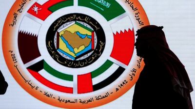 A Saudi television anchor stands in front of the logo of the 41st Gulf Cooperation Council (GCC) at the media centre at Al Ula, Saudi Arabia. AP