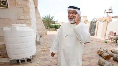 Saif Hassan talk by phone beside his water tank at his villa.