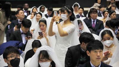 A bride takes photos before a mass wedding ceremony at the Cheong Shim Peace World Center in Gapyeong, South Korea. AP Photo