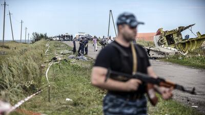 Armed pro-Russian separatists stand guard in front of the crash site of Malaysia Airlines Flight MH17, near the village of Grabove, in the region of Donetsk on July 20, 2014. The missile system used to shoot down a Malaysian airliner was handed to pro-Russian separatists in Ukraine by Moscow, says US secretary of state John Kerry. Bulent Kilic/AFP Photo