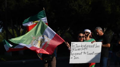 People hold pre-revolutionary Iranian flags as they protest the Iranian regime outside Carson Sports Park before Iran’s training session in Los Angeles. AFP