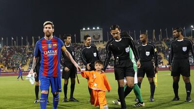 Lionel Messi holds the hands of Afghan boy Murtaza Ahmadi as the game mascot ahead of the game. Karim Jaafar / AFP