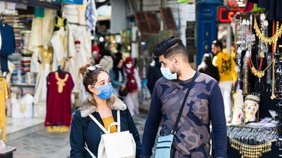 A couple walks in a street market in Tunis. Tunisia is extending its nighttime curfew by three hours and tightening other restrictions ahead of Ramadan following an uptick of COVID-19 infections. The measure will apply from Friday until at least April 30. AP Photo