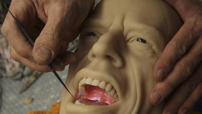 Sculptor Eric Saint Chaffray puts the teeth and tongue inside the head of Rolling Stones lead singer Mick Jagger at their workshop in Paris on March 10, 2014. Philippe Wojazer / Reuters