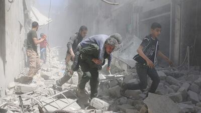 Syrians evacuate an injured man amid the rubble of destroyed buildings following an air strike in Aleppo. Ameer Alhalbi / AFP