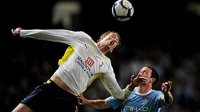 Spurs' Peter Crouch outjumps City's Wayne Bridge in Wednesday's big-money game.