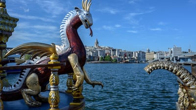 A dragon sculpture decorates an empty fish sandwich boat with the Galata Tower in the background in Istanbul, Turkey. AFP