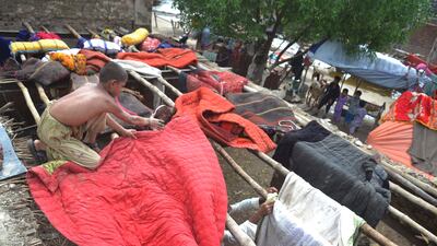 People who escaped the floods dry their belongings at a camp in the Sanghar district of Sindh province in Pakistan. EPA