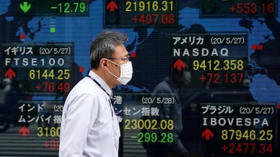 A pedestrian walks past a stock markets indicator board in Tokyo, Japan. The country's Government Pension Investment Fund posted a record loss in the first three months of 2020. EPA