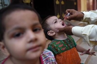 A health worker administers polio vaccine drops to a child during a door-to-door polio campaign in Karachi. Rizwan Tabassum / AFP