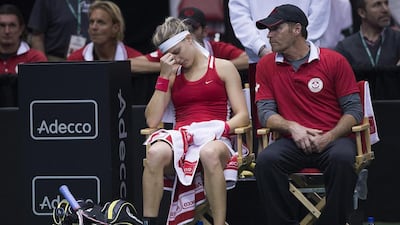 Canada's Eugenie Bouchard, front left, reacts during her Fed Cup tennis match against Romania's Andreea Mitu as coach Sylvain Bruneau, front right, looks on in Montreal, Sunday, April 19, 2015. Graham Hughes / The Canadian Press