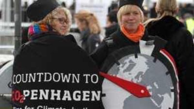Environmental activists dressed as stopwatches stand outside the venue of the Copenhagen summit on Monday.
