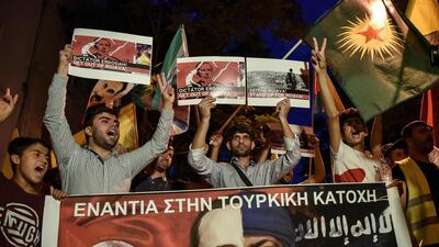 Kurds living in Athens hold flags and banners reading 'Against the Turkish occupation' as they protest near the Turkish embassy in Athens. AFP
