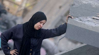 A Palestinian woman inspects the site of an Israeli strike on a house near a camp sheltering displaced people that was damaged in the strike in Khan Younis, southern Gaza. Reuters