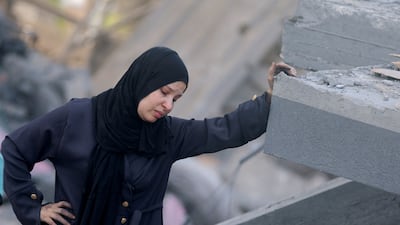 A Palestinian woman inspects the site of an Israeli strike on a house near a camp sheltering displaced people that was damaged in the strike in Khan Younis, southern Gaza. Reuters