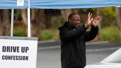 Rev. Luke Ssemakula (L) gives a blessing after hearing a parishioner's confession in the parking lot of St. Augustine Catholic Church during the ongoing coronavirus pandemic, in Pleasanton, California, USA. EPA