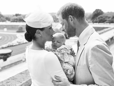 This is an official christening photo released by the Duke and Duchess of Sussex on Saturday, July 6, 2019, showing Britain's Prince Harry, right and Meghan, the Duchess of Sussex with their son Archie Harrison Mountbatten-Windsor at Windsor Castle with with the Rose Garden in the background, in Windsor, England. (Chris Allerton/©SussexRoyal via AP)
