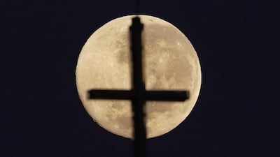 A church cross is silhouetted by the pink supermoon, in Melbourne, Australia. EPA
