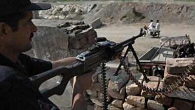 A Pakistani police commando keeps position on a rooftop post in outskirts of Peshawar, Pakistan, on Sept 14 2008.