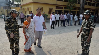 An Indian woman in Siliguri, West Bengal is helped at polling station. Reuters