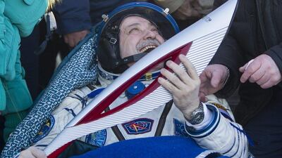 International Space Station (ISS) crew member Russian cosmonaut Fyodor Yurchikhin holds the torch of the 2014 Sochi Winter Olympic Games after landing near the town of Zhezkazgan in central Kazakhstan. Shamil Zhumatov / AFP Photo