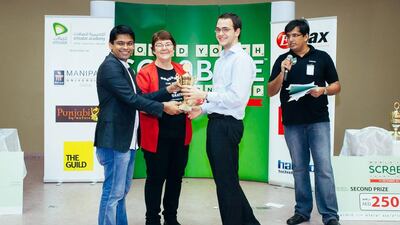 Karen Richards, second from left, presenting Alistair Richards, second from right, an award for winning the adult side tournament at the 2013 World Youth Scrabble Championship (WYSC) in Dubai. They will conduct a scrabble workshop. Courtesy of Faisal Khatib