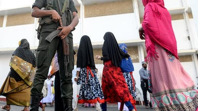 Sri Lankan Army personnel stand guard as Muslim devotees arrive to offer prayers on the first day of Eid al-Fitr at the Grand Mosque in Colombo. AFP