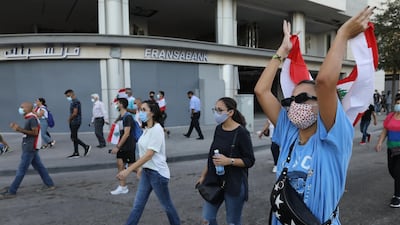 People wave Lebanese flags and chant to mark the first anniversary of anti-government protests in Beirut. Getty Images