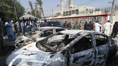 Pakistani security personnel stand next to burnt vehicles in front of the Chinese consulate in after an attack in Karachi. At least two policemen were killed. AFP