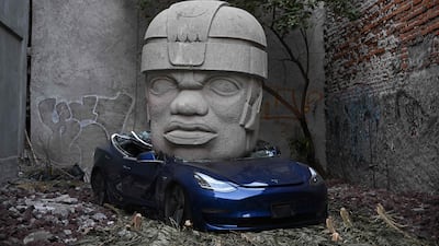 Artwork by artist Chavis Marmol of a Tesla 3 car crushed by a nine-tonne Olmec-inspired head, in Mexico City. AFP