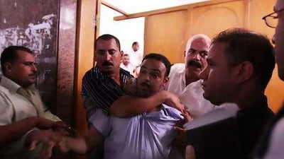 A Mamdouh Ismail is removed from the court after a scuffle with victims' relatives.