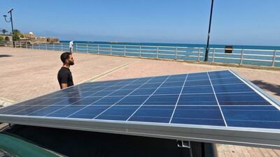 Lebanese repairman Ahmad al-Safadi stands near his custom-made electric vehicle powered by a solar panel at the corniche in port-city of Sidon, Lebanon June 23, 2022. Picture taken June 23, 2022. REUTERS / Issam Abdallah