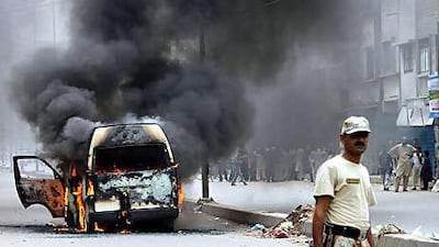 Smoke rises from a bus that had been set on fire after unrest broke out as a result of the killing of Raza Haider, a provincial legislator from Sindh Assembly, in the southern port city of Karachi.