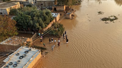 Raqqa residents wade through floodwater after heavy rain lashed northern and eastern Syria. Getty Images