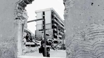 A British soldier patrols a bomb-damaged site in Kosovo in 2002.
