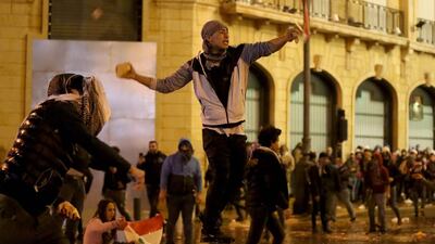 A Lebanese anti-government protester hurls stones at riot police. AFP