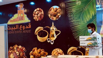 A date seller in Riyadh wears a protective face mask as he stacks boxes ahead of Ramadan. Reuters