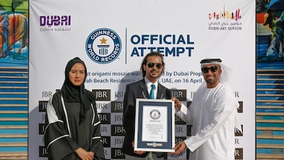 A Guinness World Record official gives Mohammed bin Essa of Dubai Properties Group the world record certificate for the origami display. Victor Besa for The National