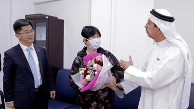 Recovered coronavirus patient Liu Yujia with China’s consul general in Dubai, Li Xuhang, and Dr Hussein Al Rand, assistant undersecretary at the Ministry of Health and Prevention. Wam / AP
