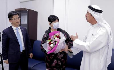 Recovered coronavirus patient Liu Yujia with China’s consul general in Dubai, Li Xuhang, and Dr Hussein Al Rand, assistant undersecretary at the Ministry of Health and Prevention. Wam / AP