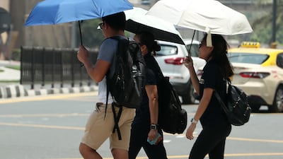 Residents take cover during hot weather in Dubai. Pawan Singh / The National
