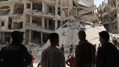 People watch as members of the Syrian Civil Defence, also known as the White Helmets, search the rubble of a collapsed building following an explosion in the town of Jisr Al Shughur, in the west of the mostly rebel-held Syrian province of Idlib. AFP