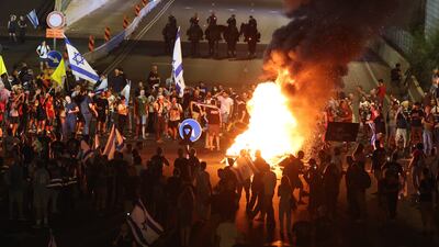Demonstrators light bonfires as they block the Ayalon main highway during a protest in Tel Aviv. EPA