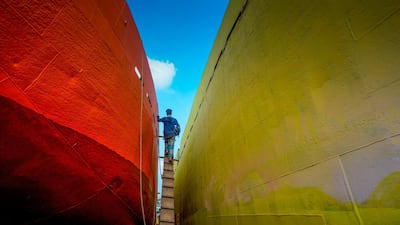 A labourer walks on a ladder to climb on a ferry at a dockyard beside the Buriganga river in Dhaka. AFP