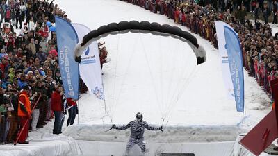 A skier uses a paraglider as he tries to cross the 26-metre long pool of water at the foot of the ski slope at Gornoluzhnik. Ilya Naymushin / Reuters / April 20, 2014