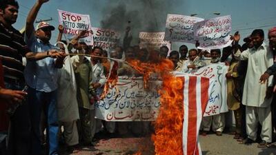 Pakistanis torch a US flag in an October 10 protest in Multan against US drone attacks in the Waziristan area.