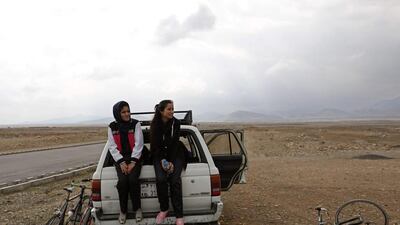 Members of Afghanistan’s Women’s National Cycling Team sit on the back of a car after a training exercise. Mohammad Ismail / Reuters