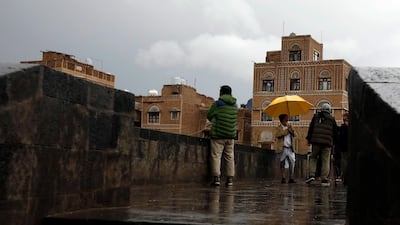 Yemenis stand on a pedestrian bridge under the rain in the old quarter of Sana'a, Yemeni. EPA