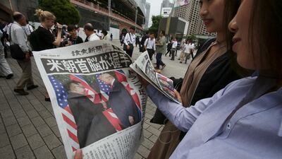 People look at an extra edition of the newspaper Yomiuri reporting about the summit, in Tokyo. Koji Sasahara / AP Photo