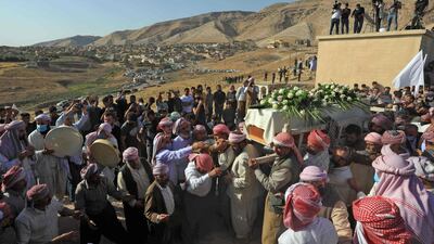 Iraqi Yazidi men surround the casket of Baba Sheikh Khurto Hajji Ismail, supreme spiritual leader of the Yazidi religious minority, during his burial in the town of Buza on October 2. AFP